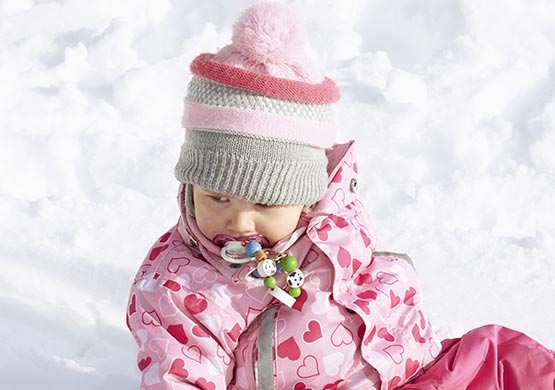 Kind im Schnee mit einer Mütze auf